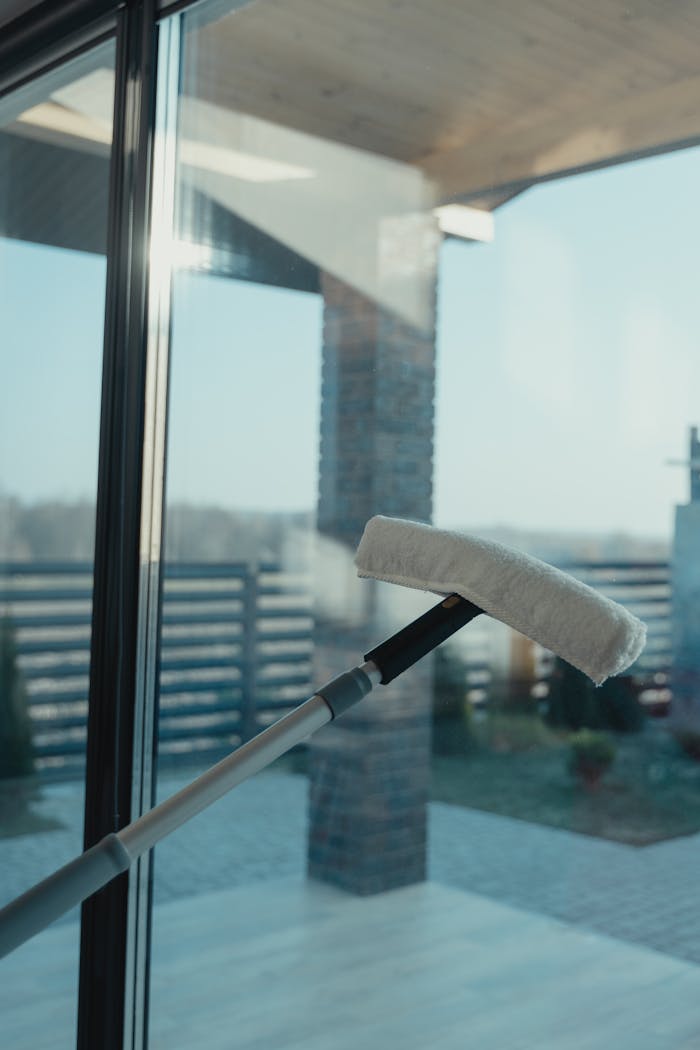 about-01 A modern cleaning tool used to clean a large glass window with a clear outdoor view.