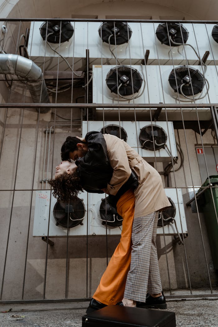 our-services-1 A couple sharing an intimate moment in front of industrial air conditioning units outdoors.